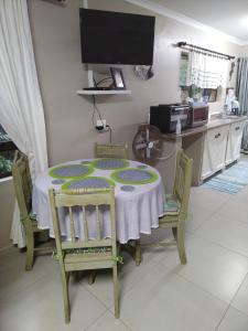 a dining room table with chairs and a tv at Dollies place in Bazley Beach