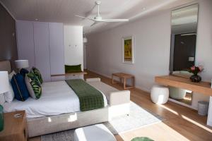 sypialnia z łóżkiem typu king-size i lustrem w obiekcie La Petite Ferme w mieście Franschhoek