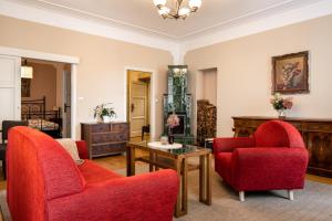 a living room with two red chairs and a table at Hygge Hotel U Zvonu in Vrchlabí