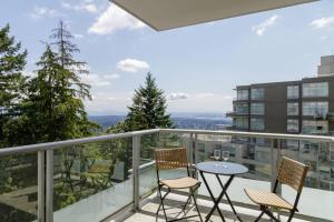 a balcony with a table and chairs and a view at Lovely 2 Bedroom condo with indoor Fireplace for 6 in Burnaby
