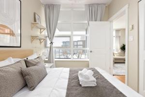 a bedroom with a white bed with towels on it at Lovely 2 Bedroom condo with indoor Fireplace for 6 in Burnaby