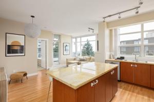 an open kitchen and living room with a counter top at Lovely 2 Bedroom condo with indoor Fireplace for 6 in Burnaby