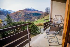 a balcony with a table and chairs and mountains at Les Tilleuls 22 - balcon vue montagne in Orcières