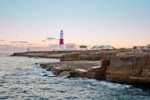 a red and white lighthouse next to the ocean at The Corner Lodge in Portland