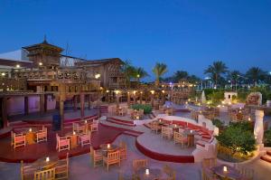 an outdoor restaurant with tables and chairs at night at Jaz Sharm Dreams in Sharm El Sheikh