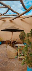 a patio with a table and an umbrella at Kasbah Ennakb in Nkob