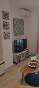 a living room with a tv and a table at Coqueto apartamento a un tiro de piedra de la playa del Portil in El Portil