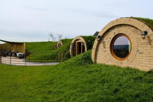 a building on a grassy hill with a round window at Rabbit Warren in Llansantffraid-ym-Mechain