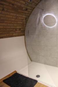 a shower with a round mirror in a room at Rabbit Warren in Llansantffraid-ym-Mechain