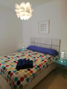 a bedroom with a bed with a colorful comforter at Coqueto apartamento a un tiro de piedra de la playa del Portil in El Portil