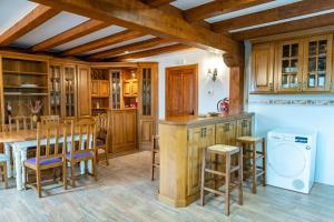 a kitchen with wooden cabinets and a table and chairs at Casa Rural La Magdalena in Hoz de Anero