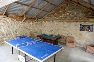 - une table de ping-pong dans une salle avec un ballon de ping-pong dans l'établissement Corderry Farmhouse, idyllic cottage amid 250 acres, à Stagdale Bridge