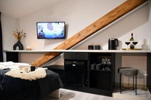 Zimmer mit einem Bett und einem TV unter einer Treppe in der Unterkunft Wine Apartments in Krakau