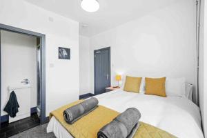 1 dormitorio con 1 cama blanca grande y 2 almohadas en Modern Equipped 4 BR House in Central Stoke-Free Parking en Stoke on Trent