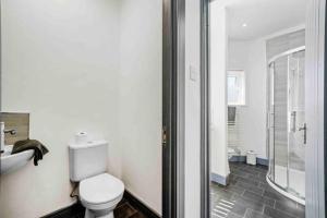 y baño con aseo, lavabo y ducha. en Modern Equipped 4 BR House in Central Stoke-Free Parking en Stoke on Trent