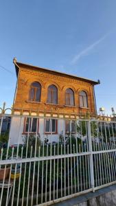 une maison avec une clôture devant elle dans l'établissement Boutique hotel, à Poti