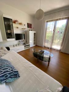 a bedroom with a bed and a table and a tv at Bright and spacious apartment with outdoor space in Kaštela