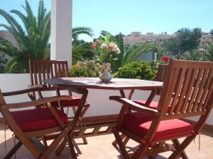 a table and chairs on a patio with a vase on it at Viviendas FERRER in Es Figueral Beach