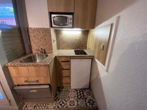 a small kitchen with a sink and a microwave at Studio cosy pour 4 pers, centre-ville de Brides-les-Bains, WIFI, animaux admis - FR-1-512-157 in Brides-les-Bains