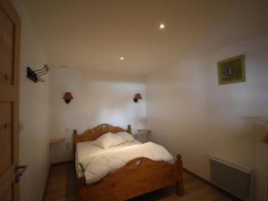 een slaapkamer met een houten bed met witte lakens bij Appartement 3 étoiles pour 6 personnes avec jardin et parking privé - Valloire, Les Clots - FR-1-263-466 in Valloire