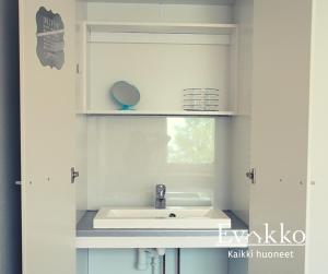 een badkamer met een wastafel en een spiegel bij Matkustajakoti Evakko in Seinäjoki