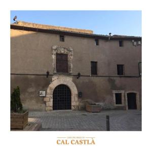 un gran edificio de piedra con una puerta y un arco en Cal Castlà, 