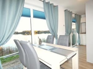 ein Esszimmer mit einem Tisch und Stühlen sowie einem großen Fenster in der Unterkunft Chalet am See in Wackersdorf