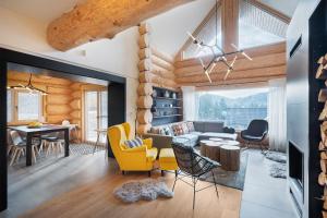 a living room and dining room with a table and yellow chairs at Chalet Ondrej Tale-Chopok-BBQ-Fire pit-Kids playground-Views in Tale