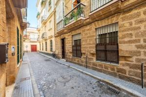 una calle vacía en un callejón entre edificios en Habitaciones La Pepa, en Cádiz