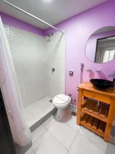 Baño púrpura con aseo y lavamanos en Aguila Blanca en Villa Gesell