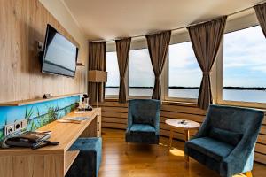 Zimmer mit 2 Stühlen und einem Schreibtisch mit einem Aquarium in der Unterkunft Seehotel Fährhaus in Bad Zwischenahn