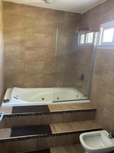 a bathroom with a bath tub and a toilet at Casa con vista a las sierras de Cordoba in Malagueño +5 photos