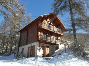 a log cabin with a balcony in the snow at ChaletauxOrres au pied des pistes et skis aux pieds in Les Orres