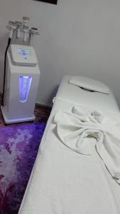 a bed with a white blanket next to a machine at Boutique hotel in Poti