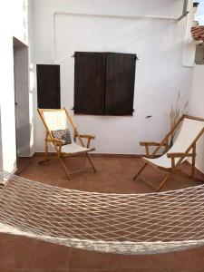 two chairs and a hammock in a room at Maison de famille bord de mer La casita blanca in L'Escala