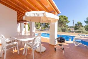 Villa Ampolla I - Costa CarpeDiem في مورايرا: فناء مع طاولة وكراسي ومظلة