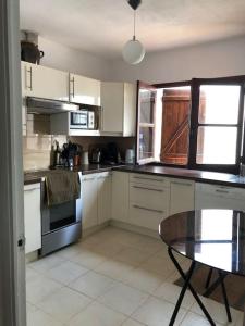 una cocina con armarios blancos y una mesa. en Maison de famille bord de mer La casita blanca, en L'Escala