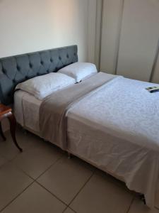 een bed met een blauw hoofdeinde in een kamer bij Apartamento próximo ao shopping pantanal in Cuiabá