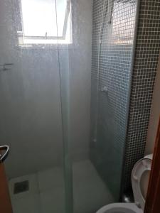 een badkamer met een glazen douche en een toilet bij Apartamento próximo ao shopping pantanal in Cuiabá