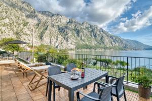 een patio met een tafel en stoelen en een berg bij Beachfront Villa Nautica in Kotor