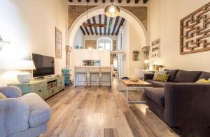 una sala de estar con un sofá y una mesa en Loft Bodega San Blas con porche y parking, en Jerez de la Frontera
