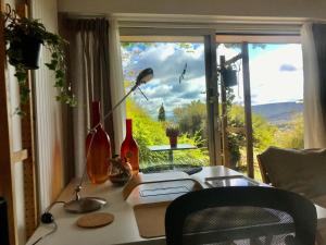 a desk in front of a window with a view at Chez Isa, espace prive, 1ou 2 chambres, terrasse et jardin, entrée autonome, sdb et mini cuisine partagées entre les 2 chambres in Ceyrat