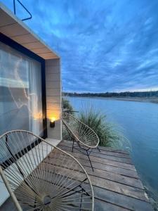 a couple of chairs sitting on a dock next to the water at Bodega Trina Suites in Río Colorado