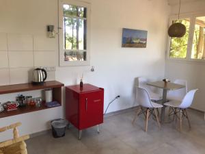 cocina con armario rojo, mesa y sillas en Bodega Trina Suites en Río Colorado