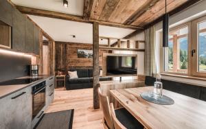 a kitchen and living room with a table and a television at Biohof Untergröber in Braies