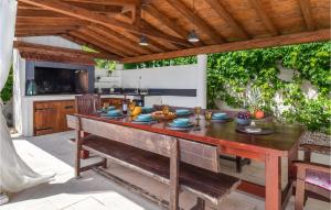 un comedor al aire libre con mesa de madera y banco en Lovely Home In Blato Na Cetini With Kitchen en Blato na Cetini