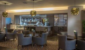 a restaurant with tables and chairs and a bar at Maldron Hotel Dublin Airport in Cloghran