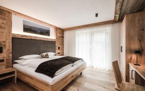 una camera con un grande letto e una finestra di Biohof Untergröber a Braies (Prags)