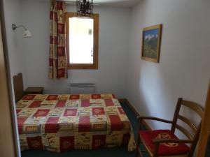 una camera con letto, finestra e sedia di Appartement Valloire, 3 pièces, 6 personnes - FR-1-263-271 a Valloire