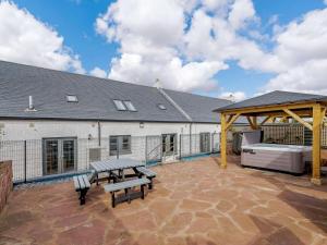 patio z 2 ławkami i stołem piknikowym w obiekcie Westertonhill Lodge 4 Newbuild with Hot Tub Option w mieście Balloch